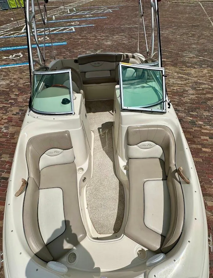 Slide: The Image of 2004 Sea Ray SunDeck 200 boat interior with beige seating and open windshield. - 37
