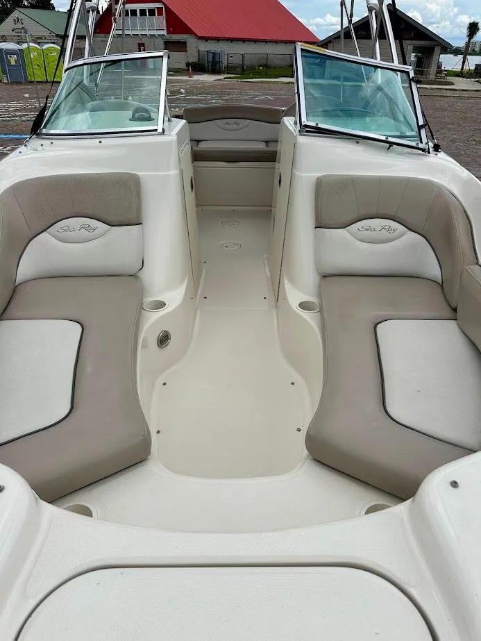 Slide: The Image of 2004 Sea Ray SunDeck 200 interior with beige seating and open deck layout. - 7