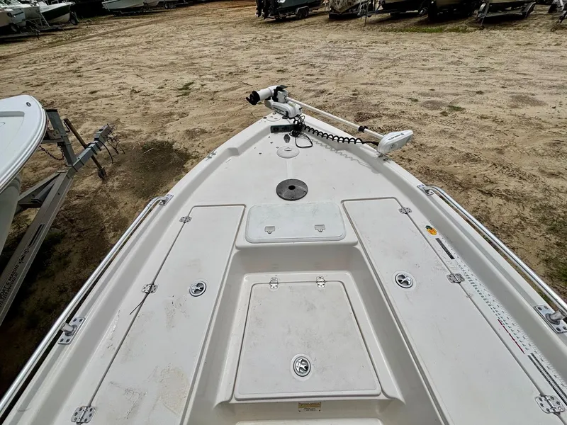 Slide: The Image of 2004 Sea Chaser 220 Bay Runner boat deck with trolling motor, parked on sandy ground. - 10