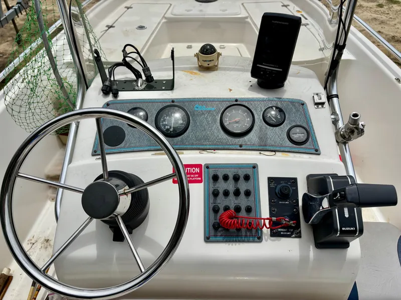 Slide: The Image of 2004 Sea Chaser 220 Bay Runner boat dashboard with steering wheel and control panel. - 9