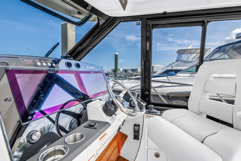 Slide: The Image of 2023 Boston Whaler 405 Conquest helm with modern controls and luxurious seating. - 11