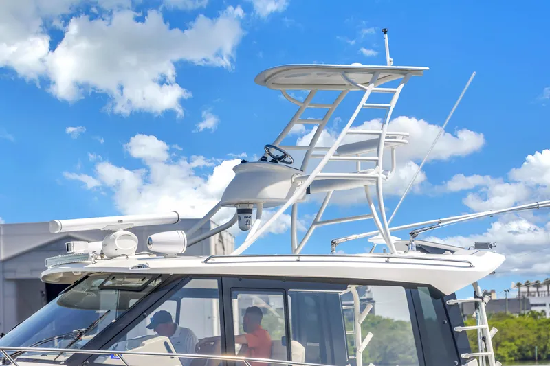 Slide: The Image of 2023 Boston Whaler 405 Conquest boat with radar and tower against blue sky. - 16