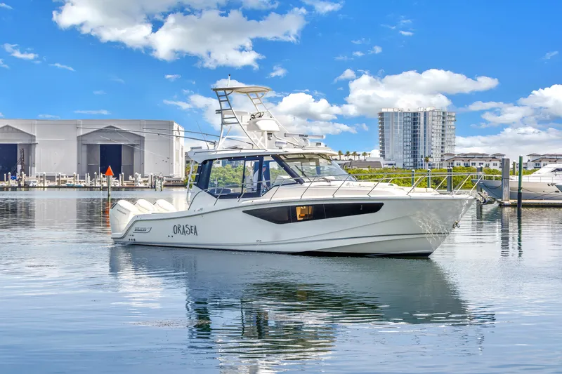 Slide: The Image of 2023 Boston Whaler 405 Conquest boat docked in marina, clear sky background. - 2