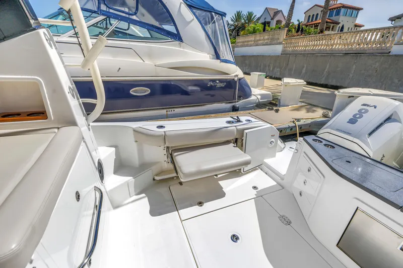 Slide: The Image of 2023 Boston Whaler 405 Conquest boat interior with seating and docked view. - 24
