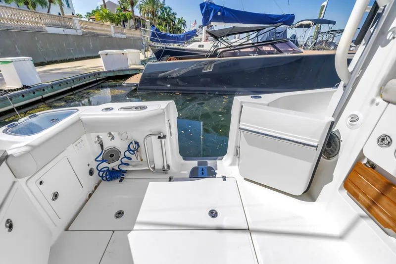 Slide: The Image of 2023 Boston Whaler 405 Conquest boat deck with open door, docked near other boats. - 25