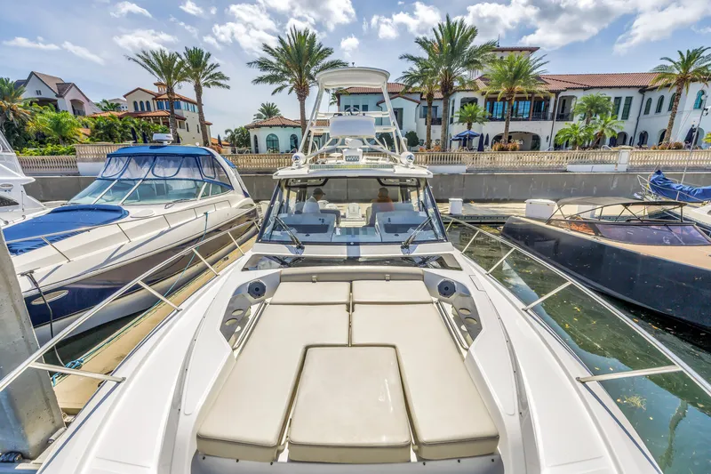 Slide: The Image of 2023 Boston Whaler 405 Conquest docked, surrounded by luxury yachts and palm trees. - 28