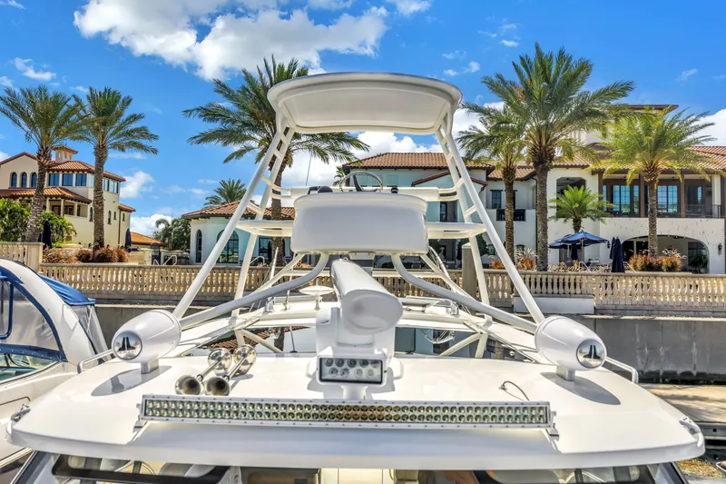 Slide: The Image of 2023 Boston Whaler 405 Conquest yacht docked near luxury waterfront homes, palm trees, and blue sky. - 30