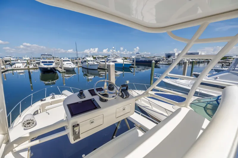 Slide: The Image of Boston Whaler 405 Conquest 2023 at marina, showcasing helm and serene waterfront view. - 33