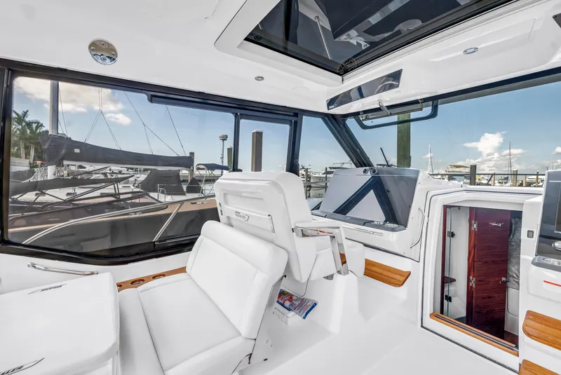 Slide: The Image of Interior of 2023 Boston Whaler 405 Conquest boat, featuring modern helm and seating. - 36
