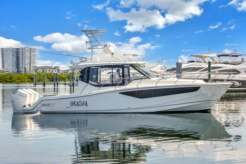 Slide: The Image of 2023 Boston Whaler 405 Conquest boat docked in marina under blue sky. - 4