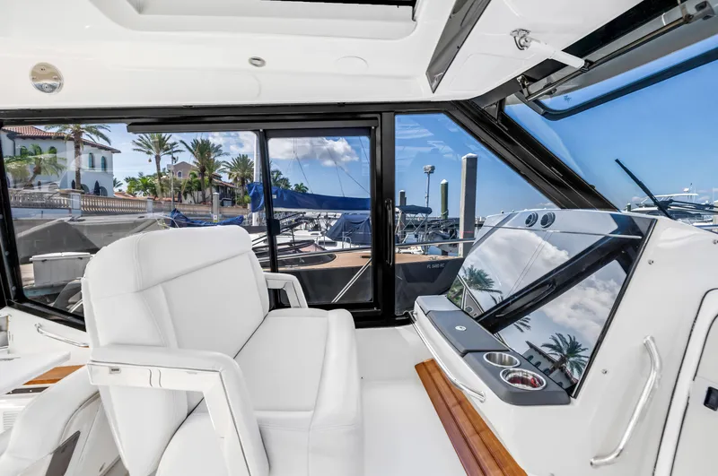 Slide: The Image of 2023 Boston Whaler 405 Conquest helm with luxurious seating and marina view. - 40