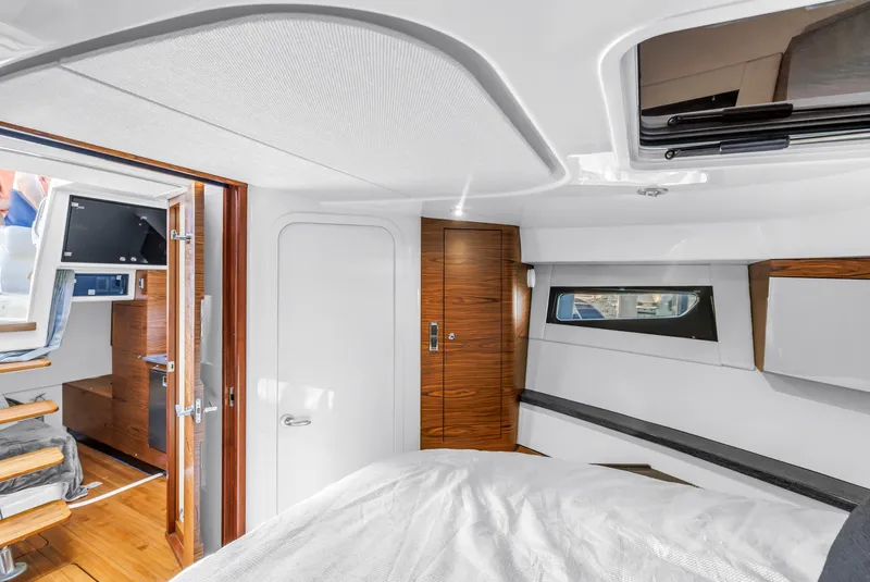 Slide: The Image of Interior of 2023 Boston Whaler 405 Conquest, featuring modern wood finishes and cozy cabin space. - 47