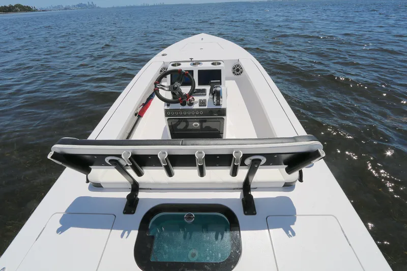 Slide: The Image of 2024 Vtech 18 boat interior with steering wheel and rod holders on open water. - 1
