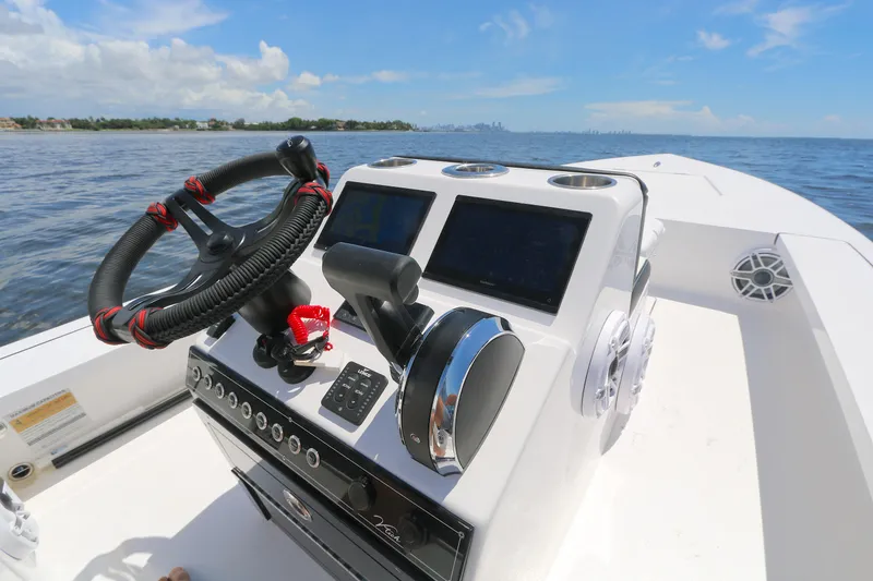 Slide: The Image of Boat dashboard with steering wheel and controls, Vtech 18 model, 2024, on open water. - 3