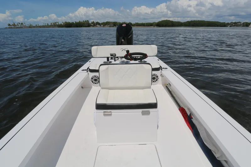 Slide: The Image of 2024 Vtech 18 boat interior on calm water, featuring seating and steering console. - 5