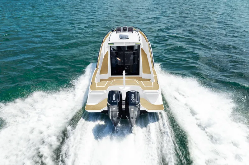 Slide: The Image of Novielli SERE 2025 boat cruising on open water, rear view with dual engines. - 12