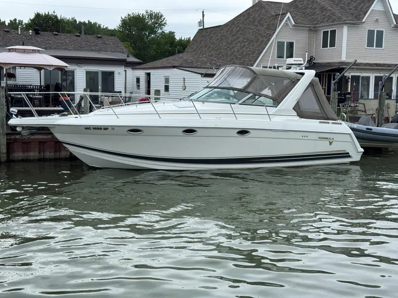 Slide: The Image of 2002 Formula 31 PC boat docked near waterfront homes. - 0