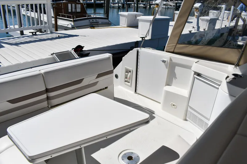 Slide: The Image of 2002 Formula 31 PC boat interior with white seating and table at marina. - 11