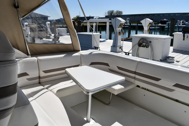 Slide: The Image of 2002 Formula 31 PC boat interior with seating and table at a marina. - 12