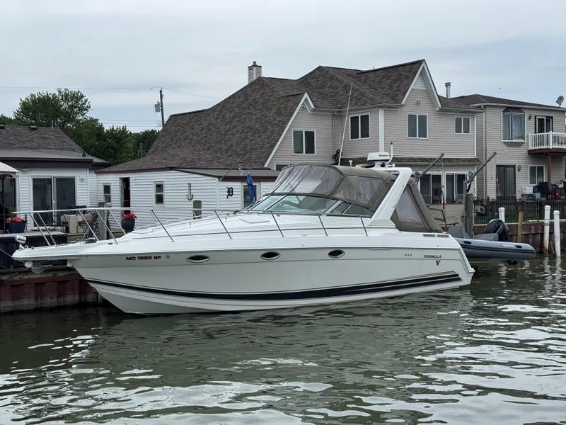 Slide: The Image of 2002 Formula 31 PC boat docked near waterfront homes. - 2