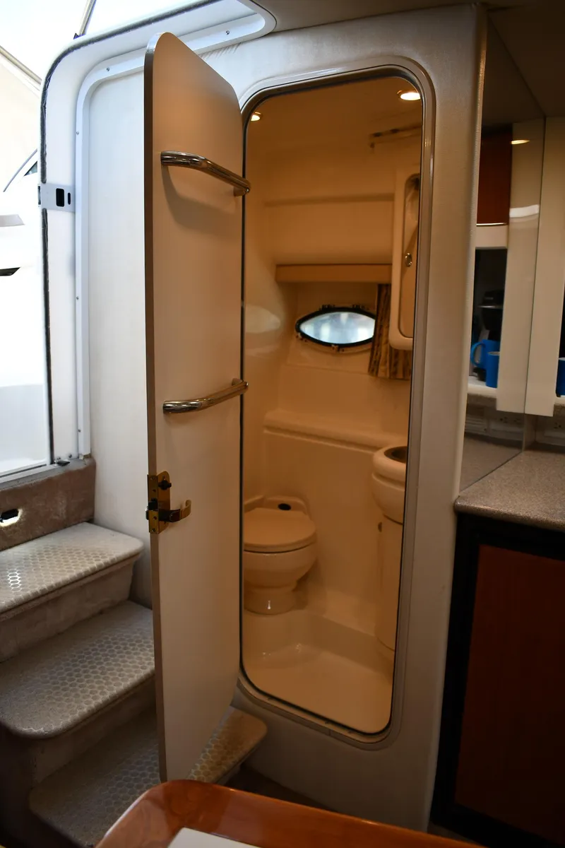 Slide: The Image of 2002 Formula 31 PC boat interior with open bathroom door, showing compact toilet and sink. - 41