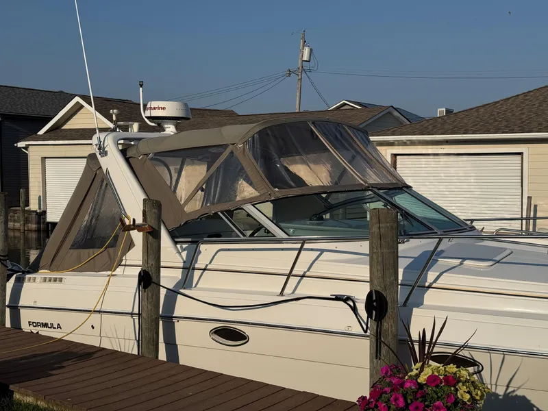 Slide: The Image of 2002 Formula 31 PC boat docked, featuring a covered cabin and vibrant flowers nearby. - 7