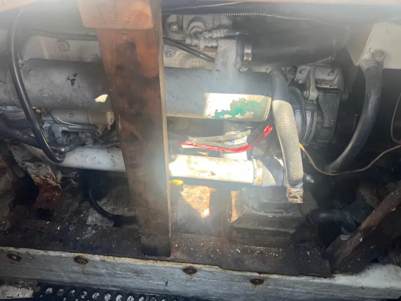 Slide: The Image of Engine compartment of a 1984 JC 35 boat, showing hoses and mechanical components. - 17