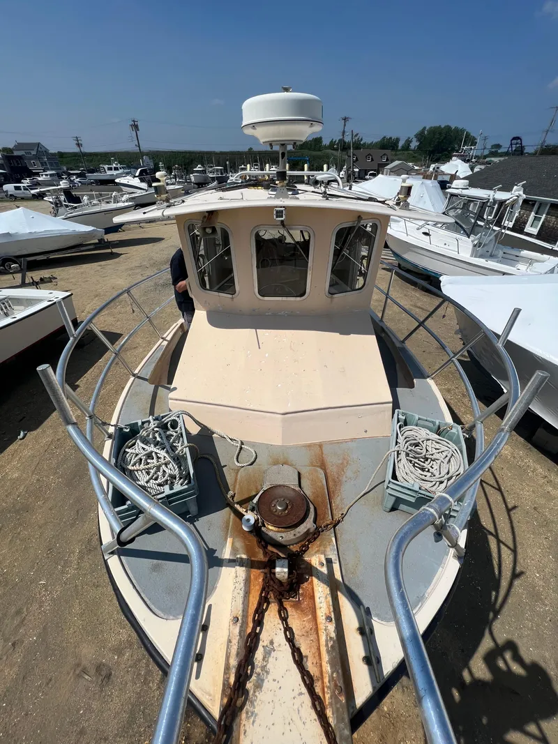 Slide: The Image of 1984 JC 35 boat on land, surrounded by other vessels, with visible ropes and anchor chain. - 8