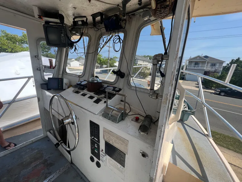 Slide: The Image of Interior of a 1984 JC 35 boat cockpit with steering wheel and navigation equipment. - 9