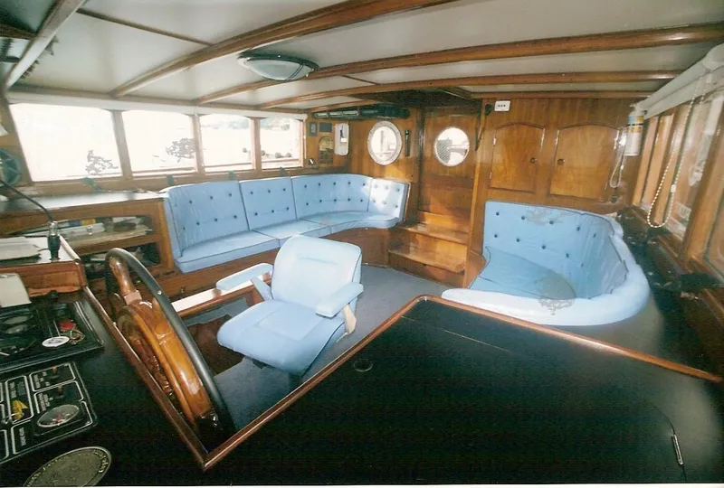 Slide: The Image of Interior of 1991 Custom Horacio Carabelli Schooner with blue seating and wooden accents. - 10