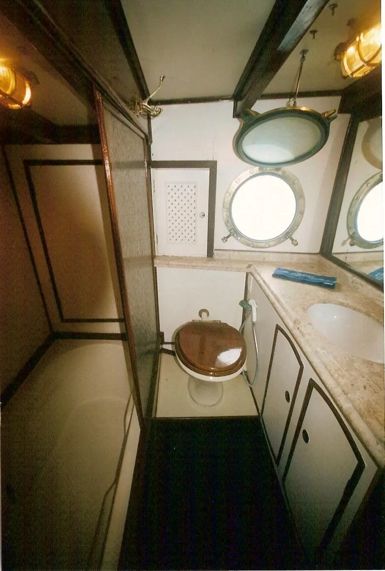 Slide: The Image of Bathroom interior of 1991 Custom Horacio Carabelli Schooner with porthole window and wooden accents. - 24