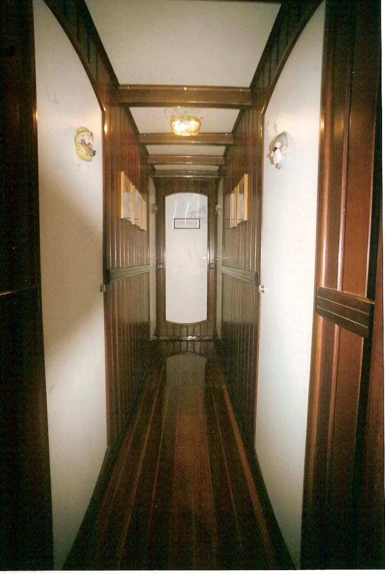 Slide: The Image of Narrow wooden hallway inside 1991 Custom Horacio Carabelli Schooner, featuring elegant paneling and lighting. - 27