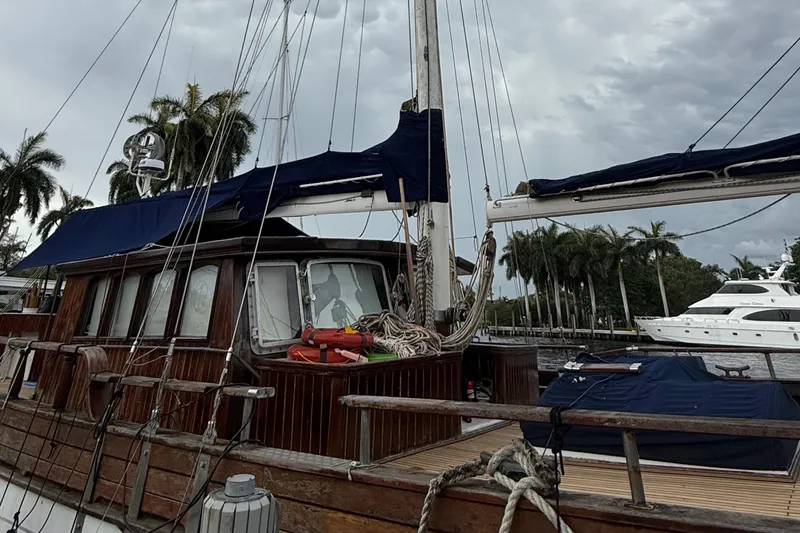 Slide: The Image of Custom 1991 Horacio Carabelli Schooner docked, featuring wooden cabin and blue sails. - 34