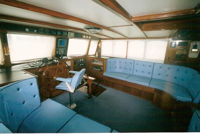 Slide: The Image of Interior of 1991 Custom Horacio Carabelli Schooner with blue seating and wooden helm. - 9