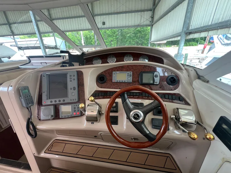 Slide: The Image of 2004 Sea Ray 480 Motor Yacht helm with navigation instruments and wooden steering wheel. - 14
