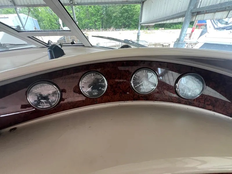 Slide: The Image of 2004 Sea Ray 480 Motor Yacht dashboard with gauges, under a covered dock. - 17