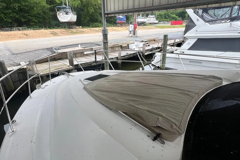 Slide: The Image of 2004 Sea Ray 480 Motor Yacht docked under a covered marina, with nearby boats visible. - 25