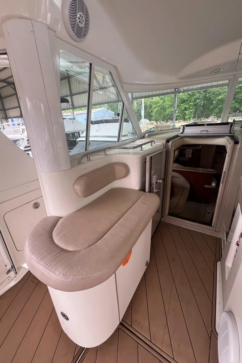 Slide: The Image of 2004 Sea Ray 480 Motor Yacht interior with cushioned seating and wooden flooring. - 26