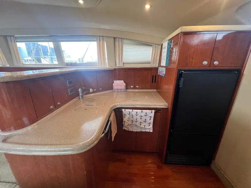Slide: The Image of Luxurious 2004 Sea Ray 480 Motor Yacht kitchen with sleek wood cabinetry and modern appliances. - 34