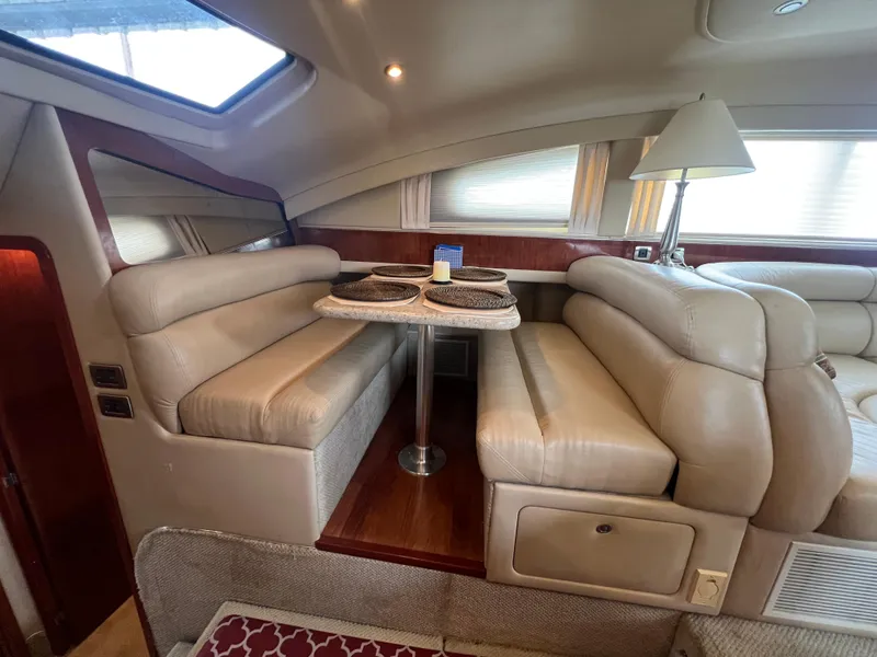 Slide: The Image of 2004 Sea Ray 480 Motor Yacht interior with beige leather seating and dining table. - 36