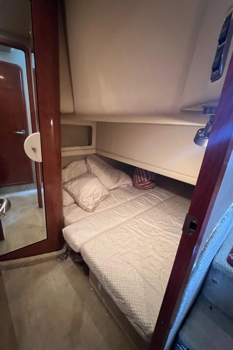 Slide: The Image of 2004 Sea Ray 480 Motor Yacht cabin with cozy bed and wooden interior. - 39