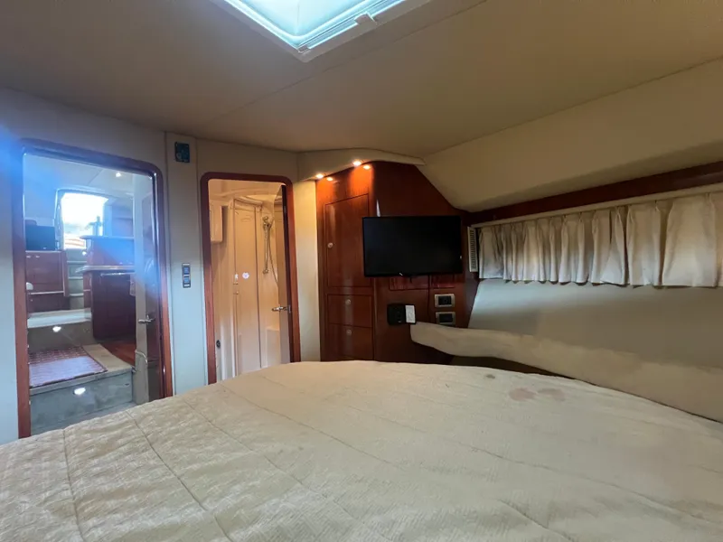 Slide: The Image of 2004 Sea Ray 480 Motor Yacht interior cabin with bed, TV, and bathroom. - 42