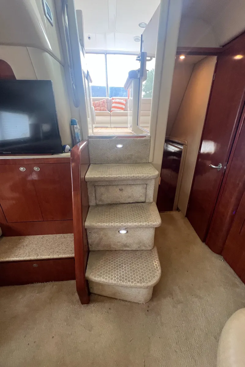 Slide: The Image of Interior of 2004 Sea Ray 480 Motor Yacht with carpeted stairs and wooden cabinetry. - 45