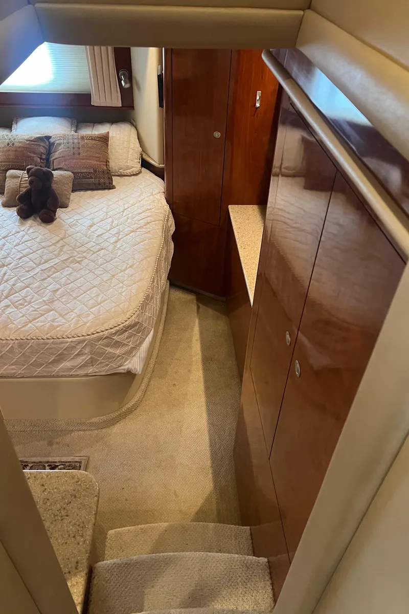 Slide: The Image of Interior of 2004 Sea Ray 480 Motor Yacht bedroom with bed, pillows, and wooden cabinetry. - 46