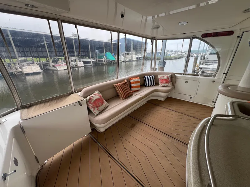 Slide: The Image of 2004 Sea Ray 480 Motor Yacht interior with cushioned seating and marina view. - 7