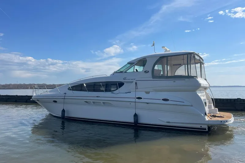 Slide: The Image of 2004 Sea Ray 480 Motor Yacht docked on calm water under a clear blue sky. - 70