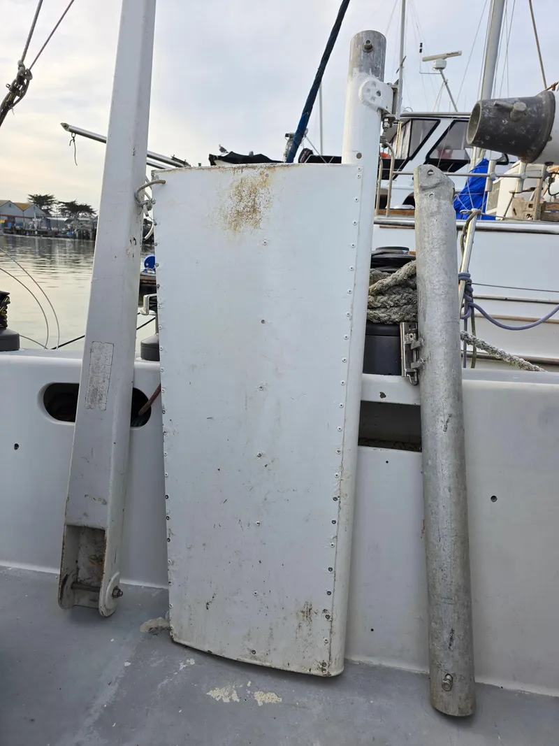 Slide: The Image of Sailboat parts on deck of 1986 Santa Cruz 50, including rudder and mast components. - 13