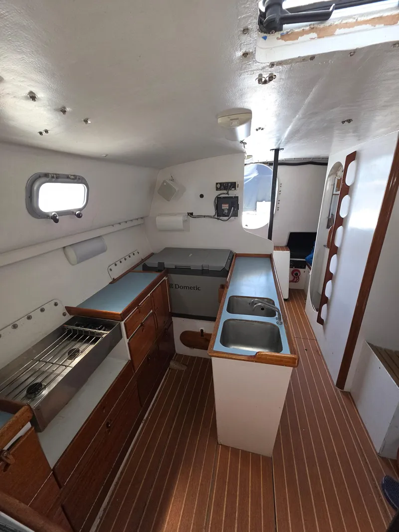 Slide: The Image of Interior of 1986 Santa Cruz 50 yacht with kitchen and wooden flooring. - 17