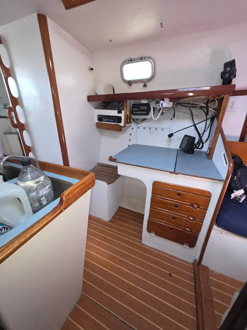 Slide: The Image of Interior of 1986 Santa Cruz 50 sailboat with navigation station and wooden accents. - 19