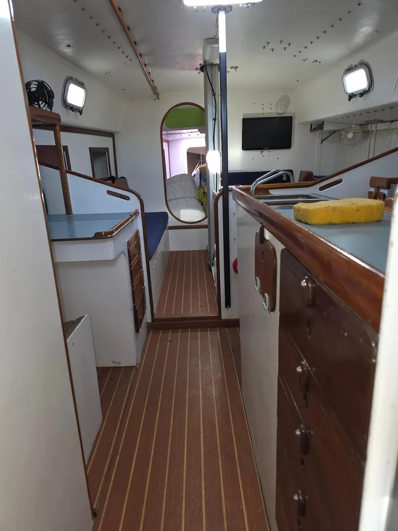 Slide: The Image of Interior of a 1986 Santa Cruz 50 sailboat with wooden flooring and compact design. - 20